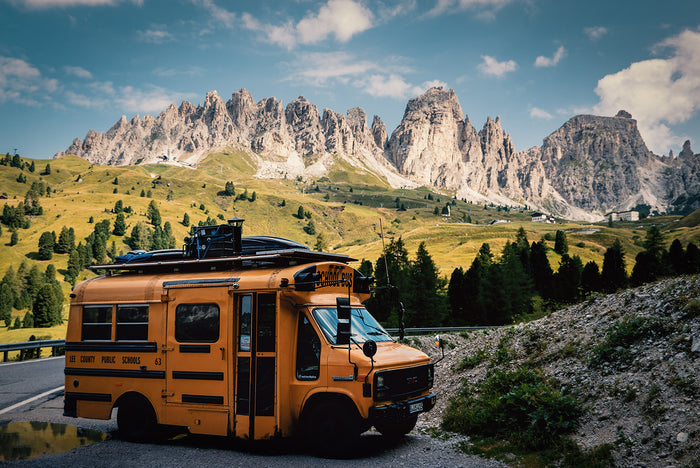 Yellow US American school bus standing in front of a mountain chain in Corsica. (Photo: Kai Branss)