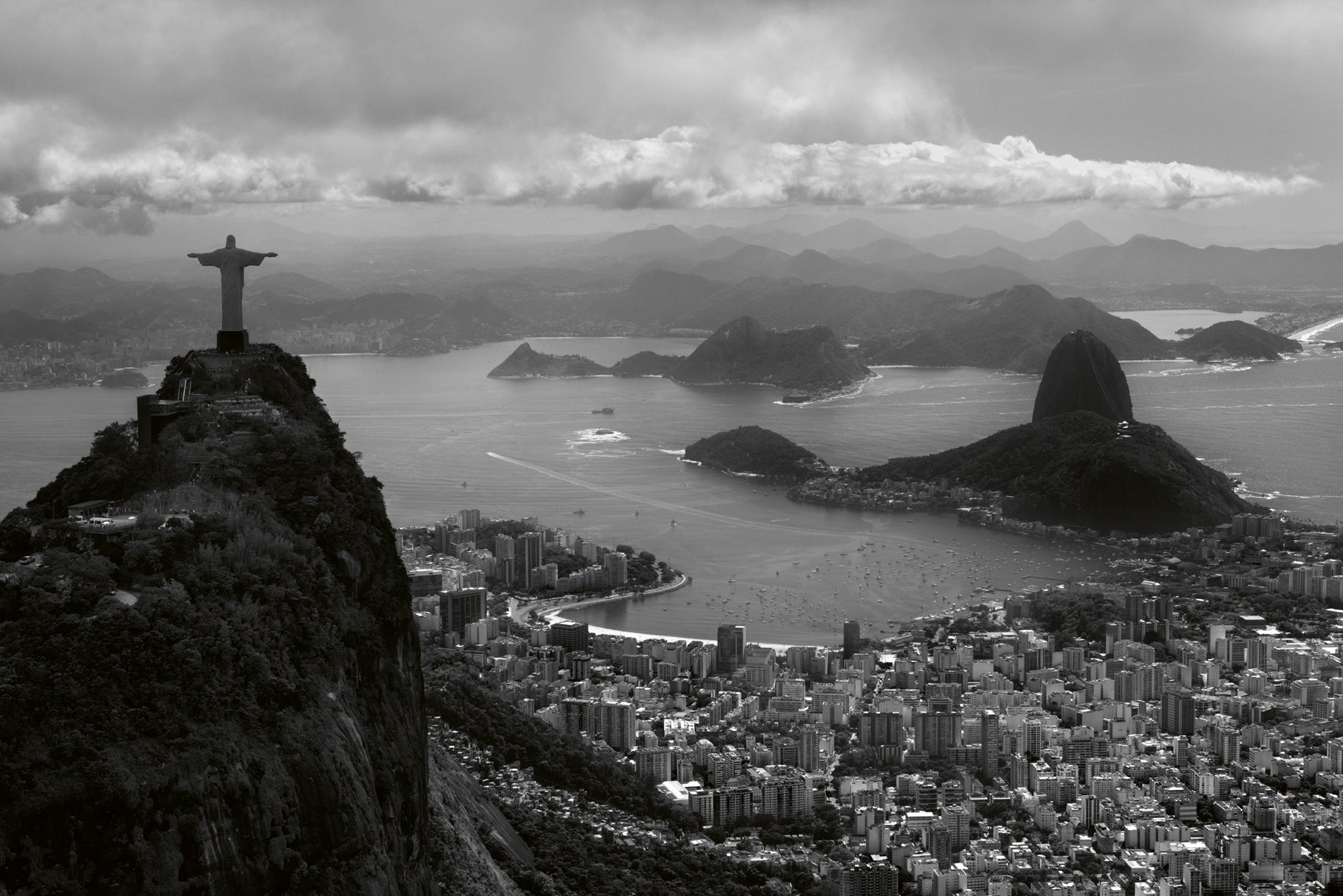 Black and white view of Rio de Janeiro with Christ the Redeemer statue and cityscape.