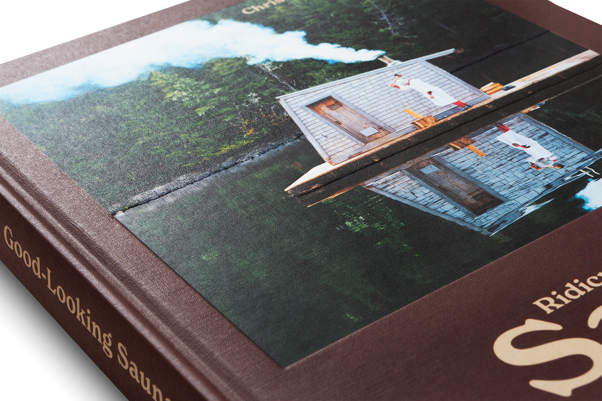 Close-up of a book with a scenic cover featuring a houseboat on water.