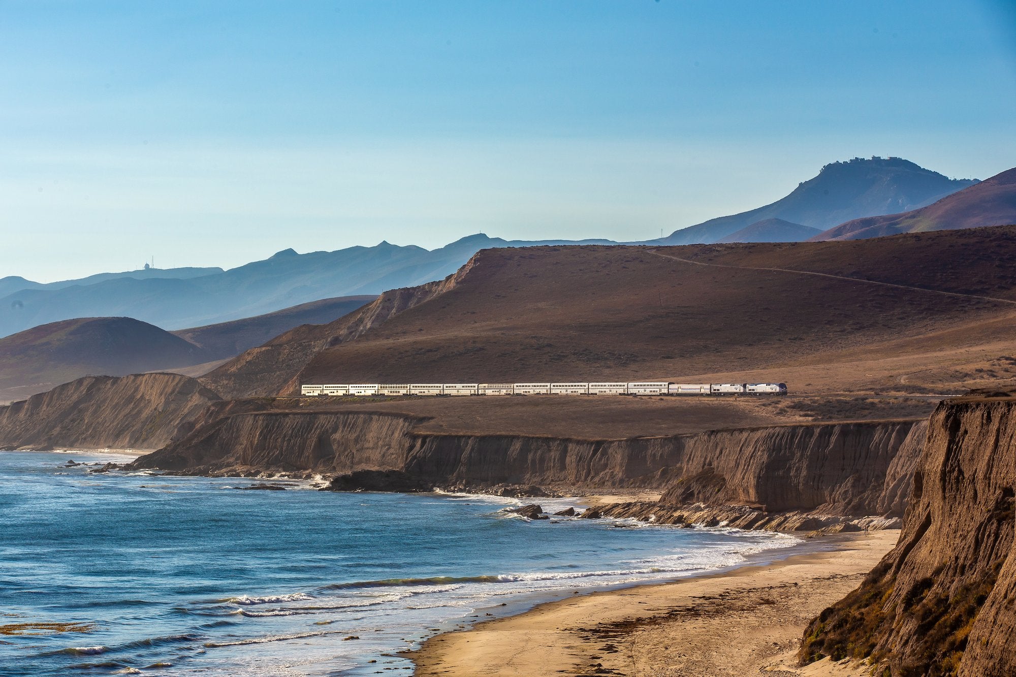 Diese spektakuläre Strecke verbindet die wichtigsten Städte der amerikanischen Westküste auf einer Reise voller glorreicher Meerblicke. Entdeckt die Coast Starlight in Zugvögel von Monisha Rajesh