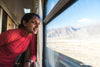 Monisha Rajesh in einem Zug. Sie ist Bahnreisende aus Leidenschaft und stellt in Zugvögel 42 der weltweit schönsten Zugstrecken vor.