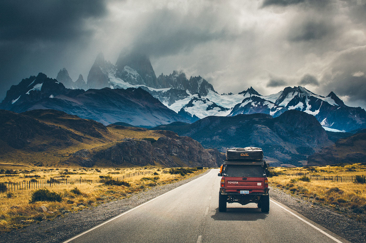 An offroad vehicle on an empty road, in the background snow capped mountains. (Photo: Richard Giordano)