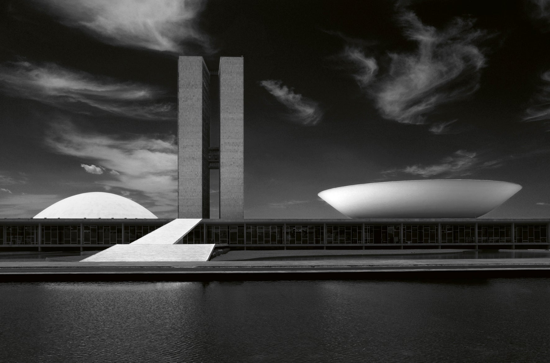 Modern architectural structure with geometric shapes against a cloudy sky