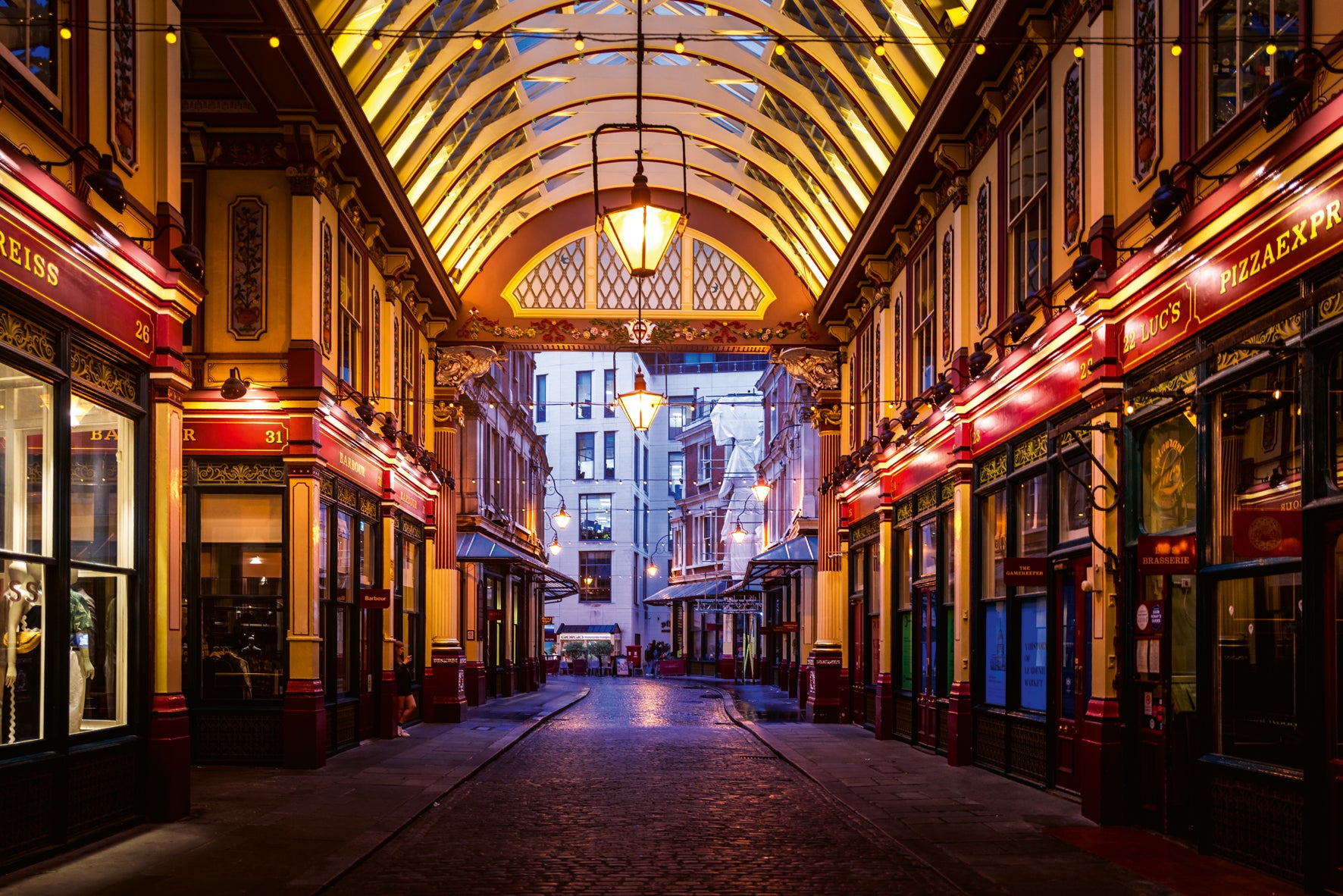 Tiled arcade with shops on a city street at night