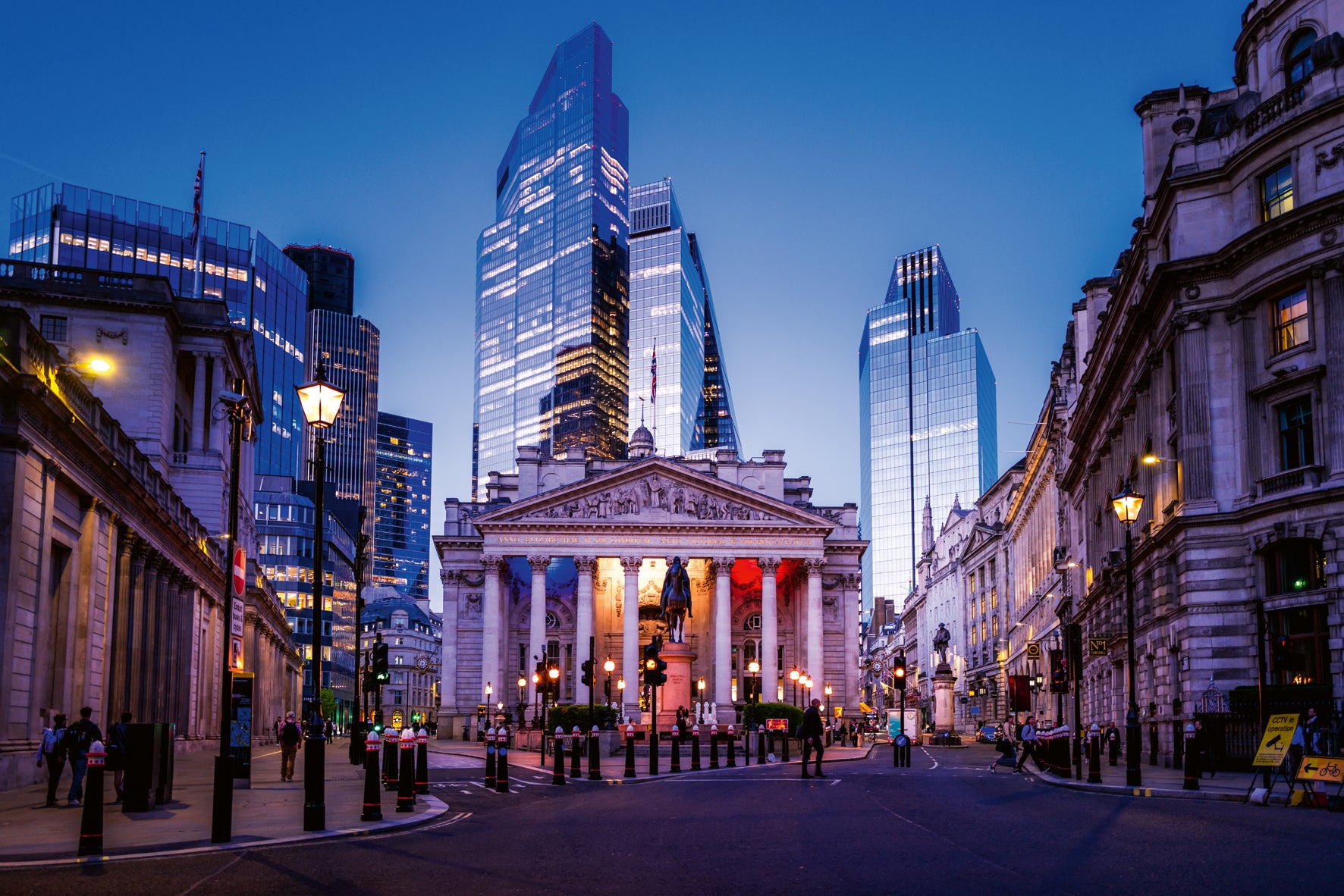 City street with classical architecture building and modern skyscrapers at dusk.