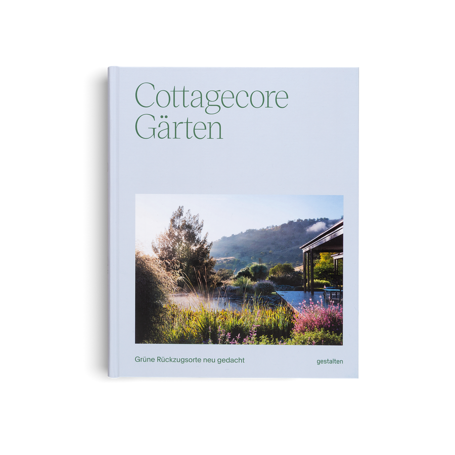 Book titled 'Cottagecore Gärten' with a scenic garden cover on a light blue background