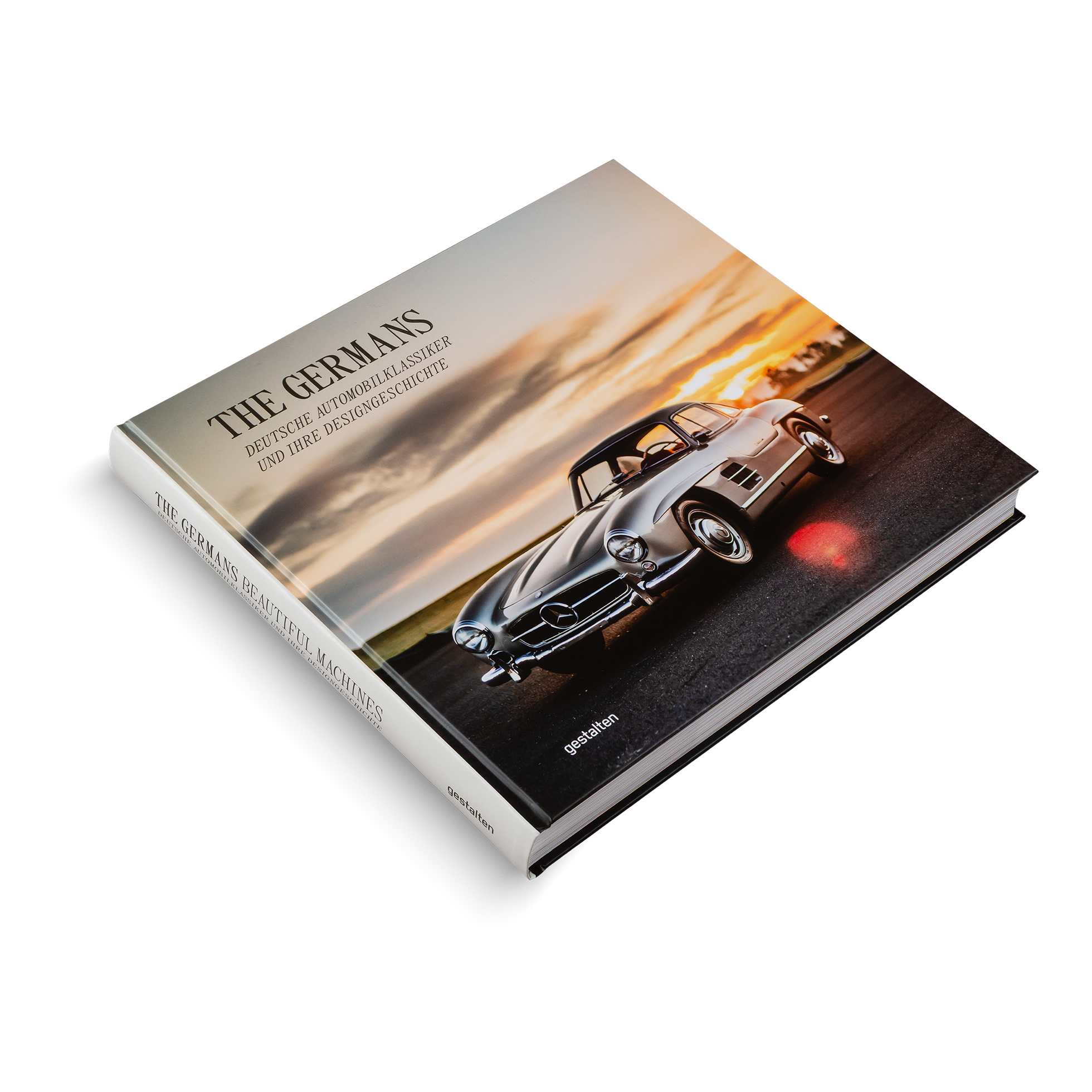 Book titled 'The Germans' with a vintage car on the cover against a sunset background