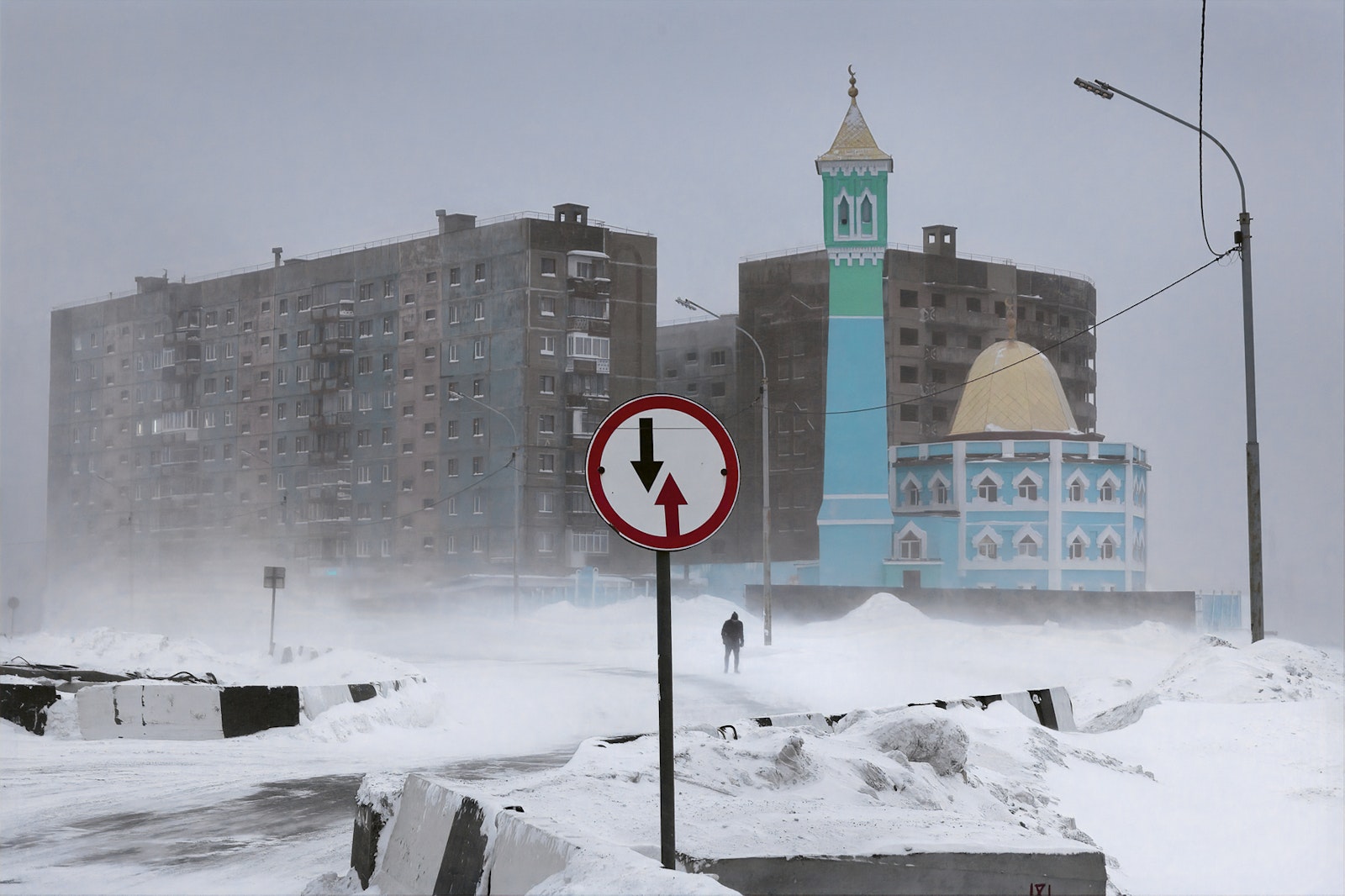 Snowy urban scene with a mosque and traffic sign in the foreground