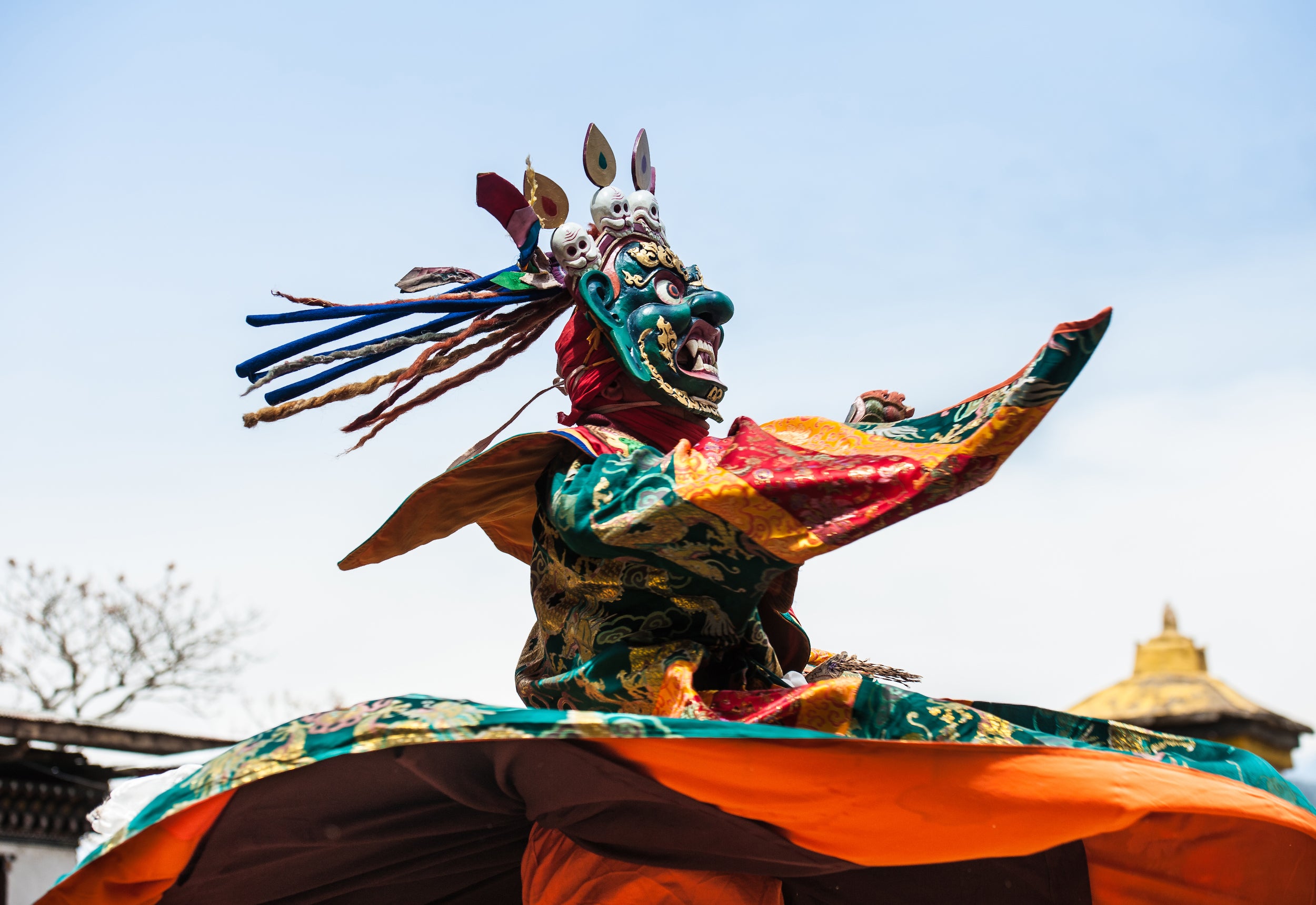 Ein kostümierter und maskierter Tänzer bei einem buddhistischen Tsechu-Fest. Wanderlust Himalaya zeigt die beste Wanderwege in Bhutan.