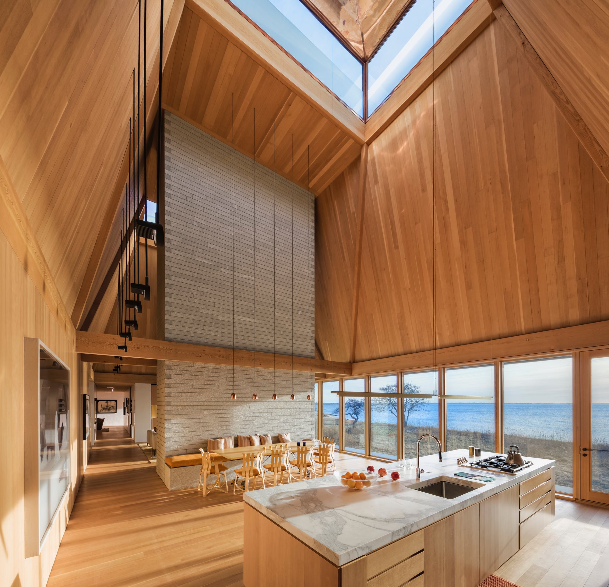 The rich tone of wood of this incredible house is continued in the chairs, table, flooring, and cabinetry, with complementary seating upholstered in creamy hues. Find out more in Out of the Woods by gestalten.