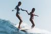 Two female surfers on a wave in She Surf