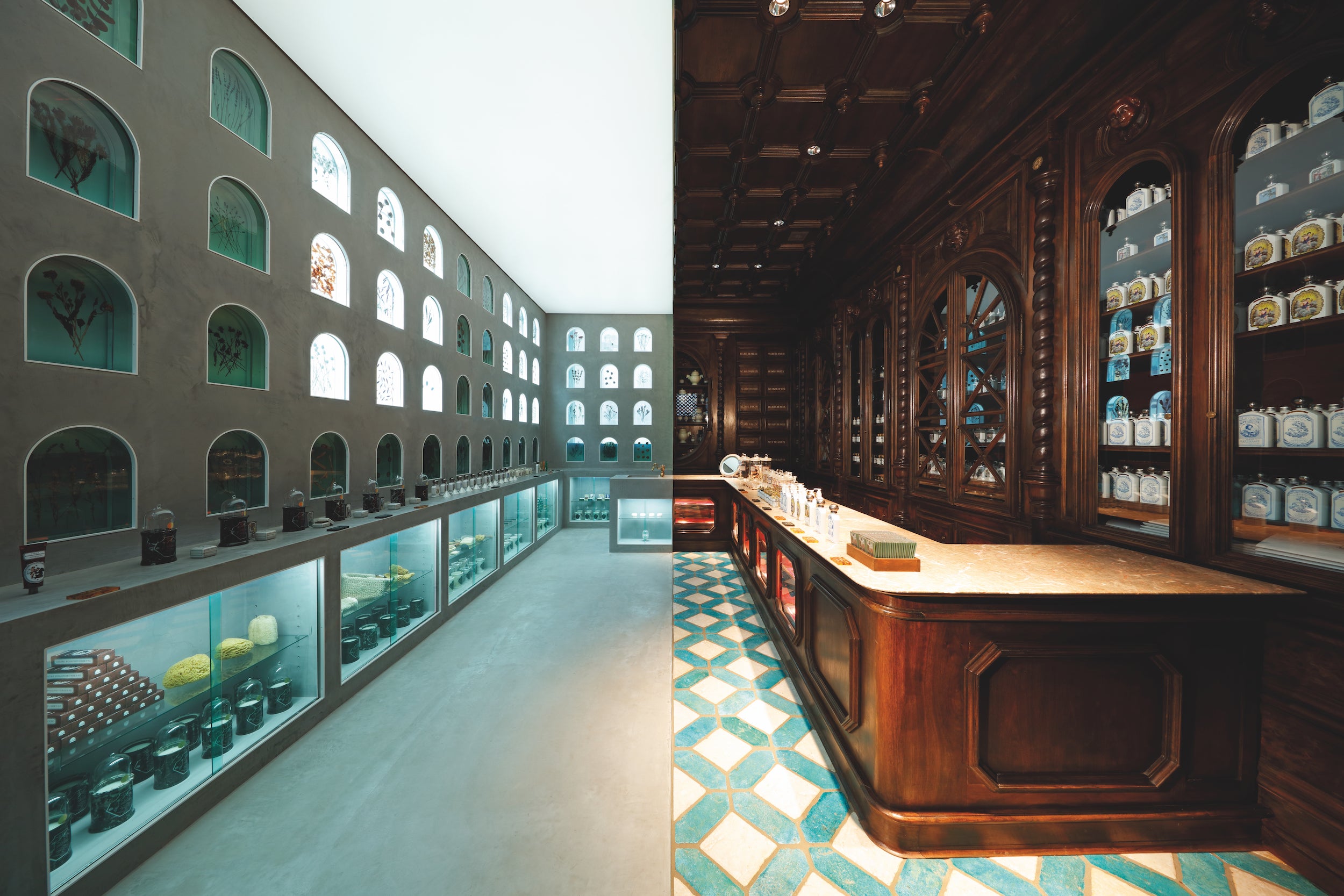 Officine Universelle Buly’s shop in Tokyo represents an architectural  extravagance—a space that embodies the bridges built by Buly be- tween eras and cultures. This audacity was rewarded with two  prizes at the 2018 Frame Awards. One half of this bisected store is  straight out of 19th-century France: marvellously refined wooden or- naments—pillars with helicoidal engaged columns, candelabras with  their bobeches, dentil frieze, cornice, and coffered ceiling—are on display, like a Haussmanian facade.