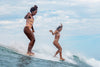 Deux femmes surfent sur une vague au Mexique dans l’Etat de Nayarit, le paradis de la glisse facile. Découvrez plus sur ce spot de surf dans l’Atlas du surf.