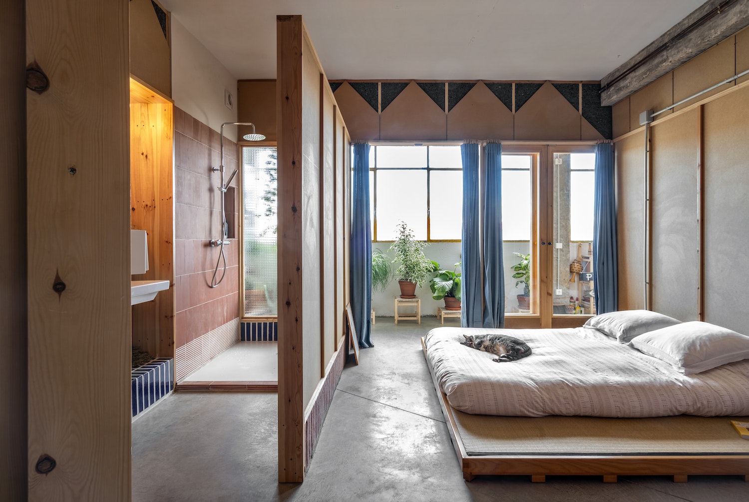 Partitions in brick and MDF panels jut out from the central columns in a joyous zigzag formation. Constructed from glazed bricks in terra-cotta, white, and cobalt blue on pine frames, they achieve a combination of solidity and lightness that adds to the spaciousness of the home, as well as being inherently decorative.