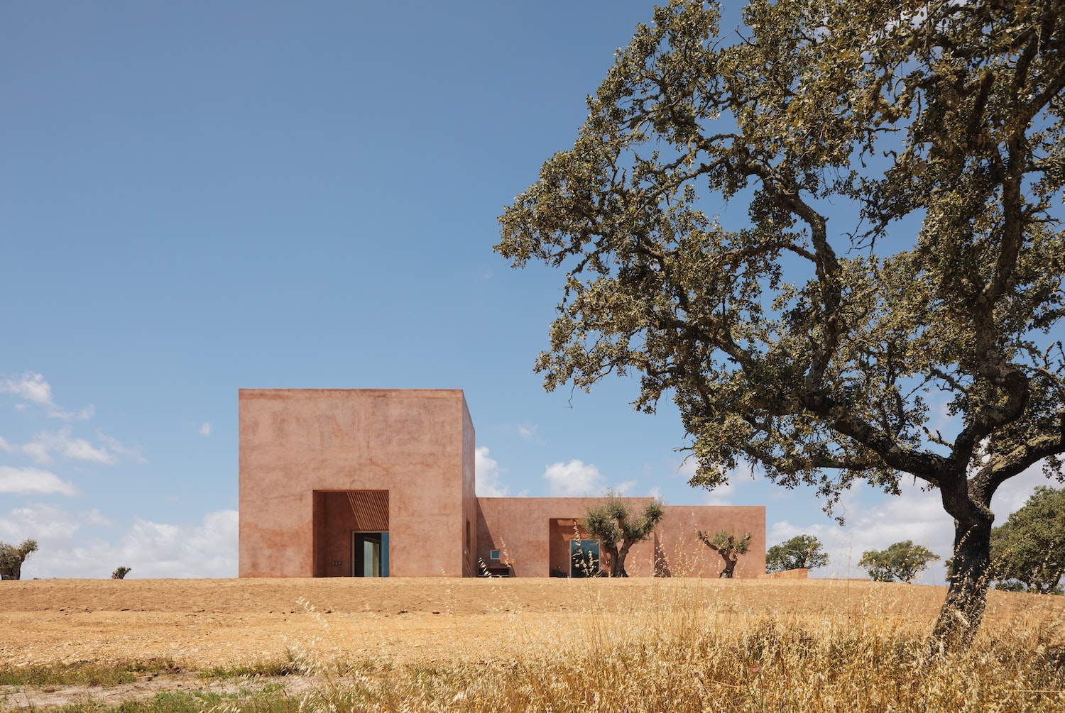Casa Azul was directly informed by the surrounding landscape. After visiting the site in the arid Alentejo region of southern Portugal, Lisbon-based Bak Gordon Arquitectos developed a design around two “fresco” rooms that rise at either end of the largely single-story holiday home. 