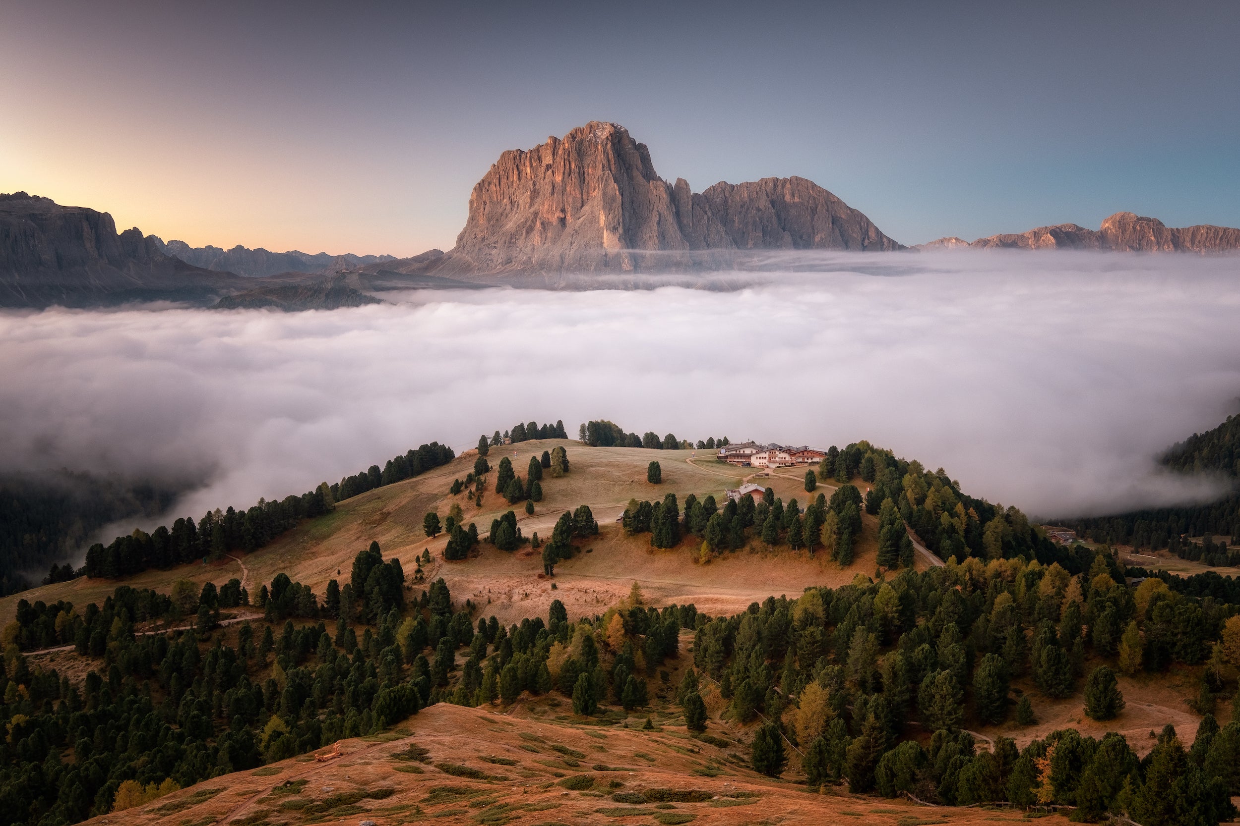 In der Morgendämmerung bietet sich ein unvergesslicher Blick auf die Dolomiten, die aus den Wolken hervorschauen. 